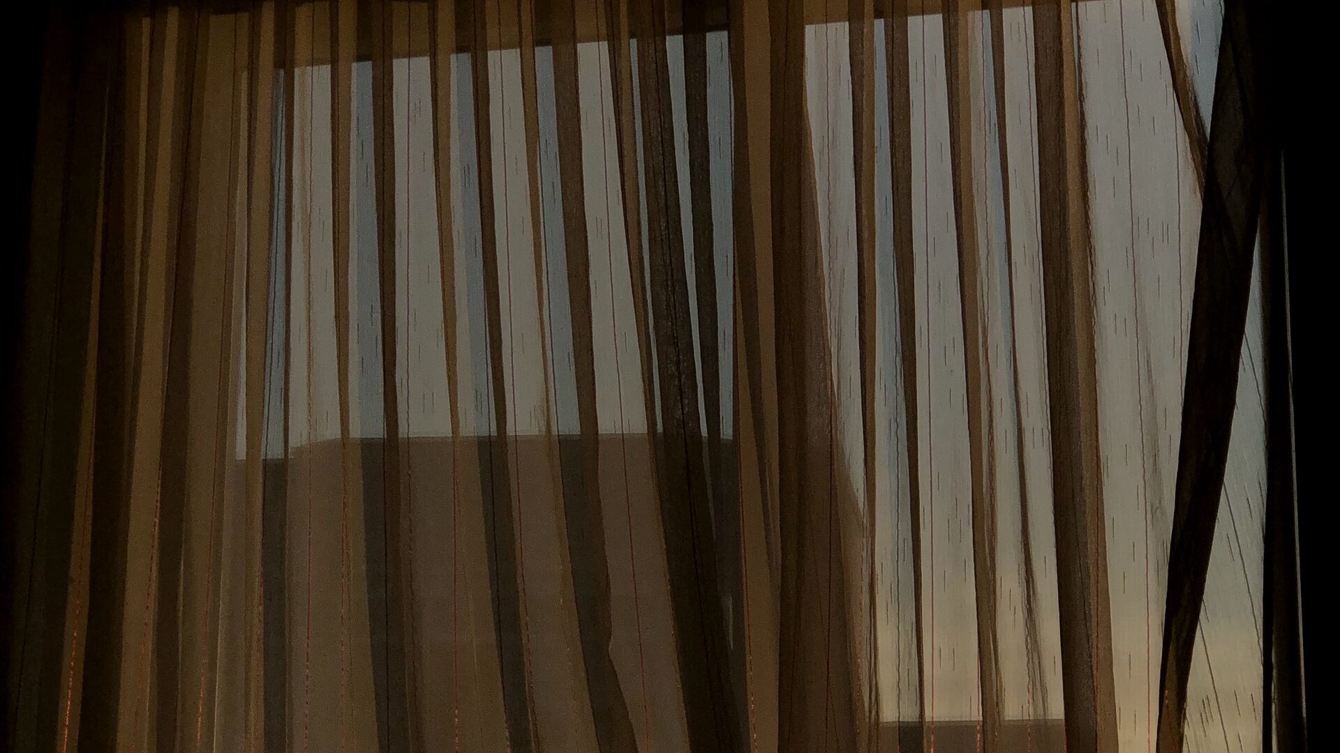 傍晚的暖光透过窗帘照进安静的房间